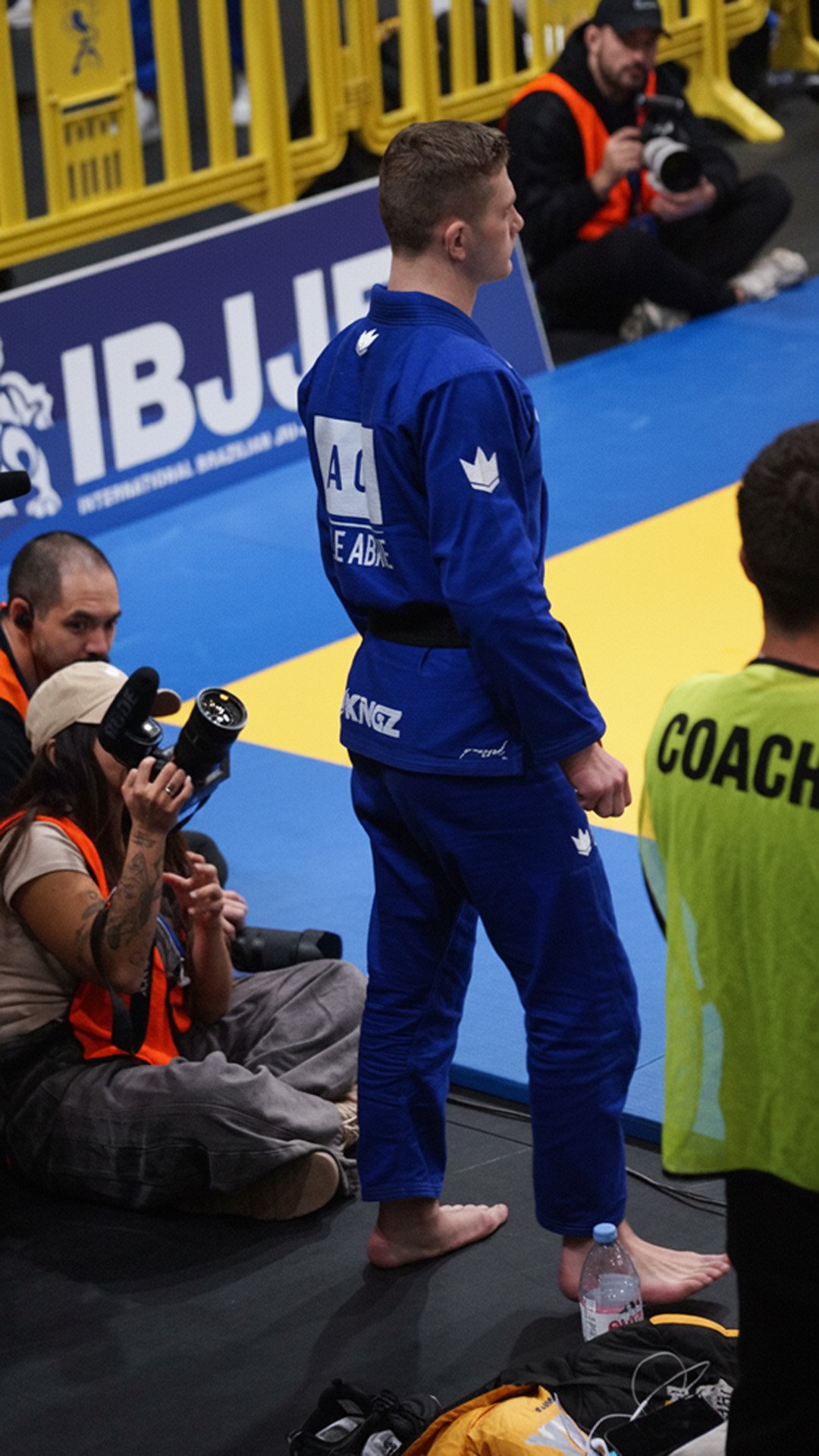 Athlète en kimono bleu entrant dans la zone de compétition